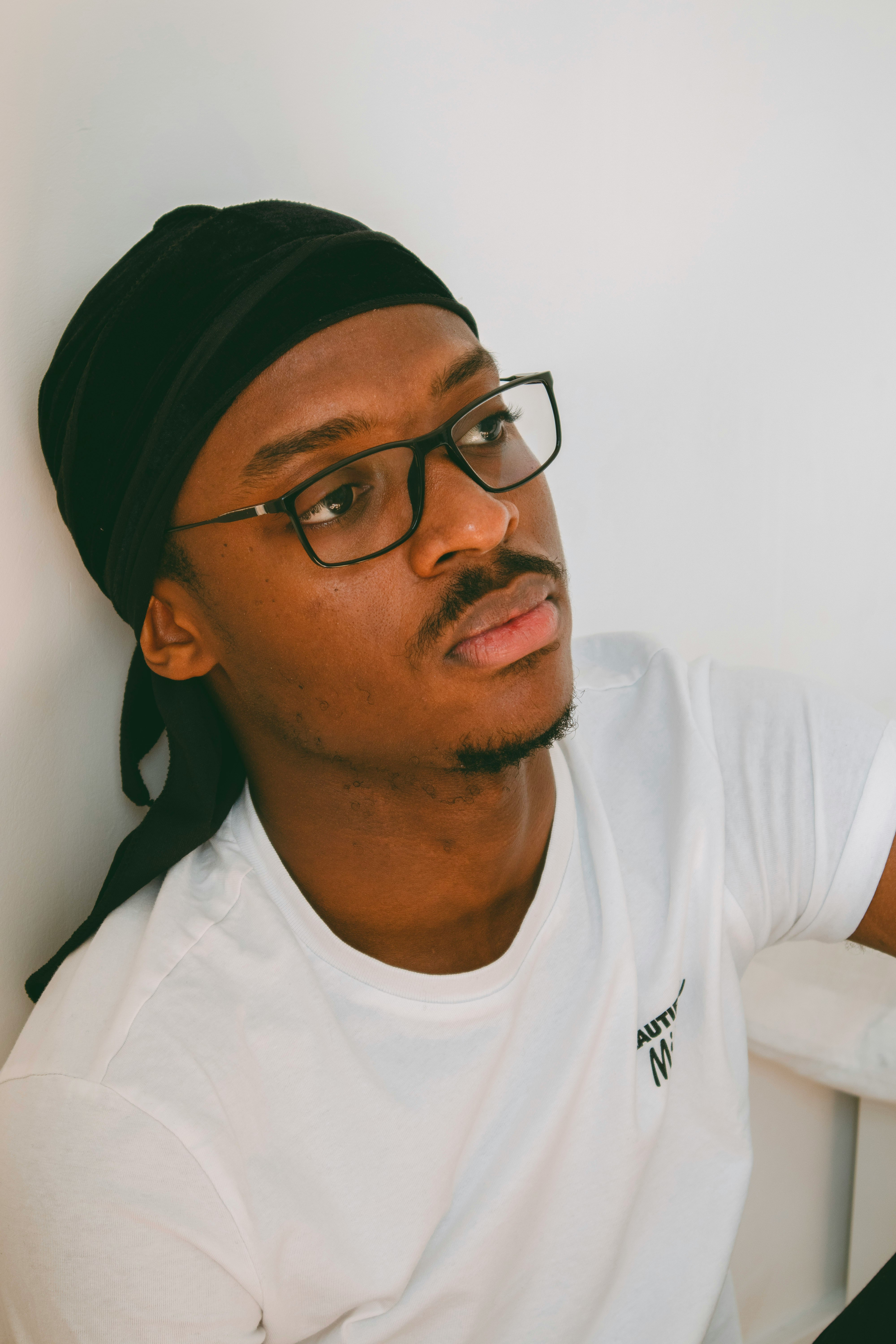 man in white crew neck shirt wearing black framed eyeglasses